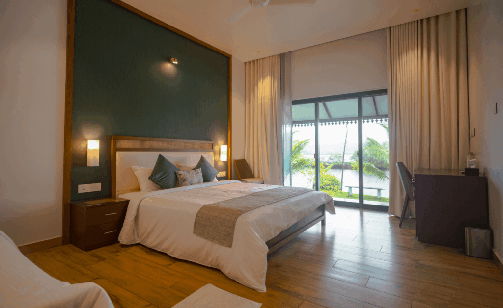 Bedroom at Pavizhamalli villa looking out to the water at Giby Farm