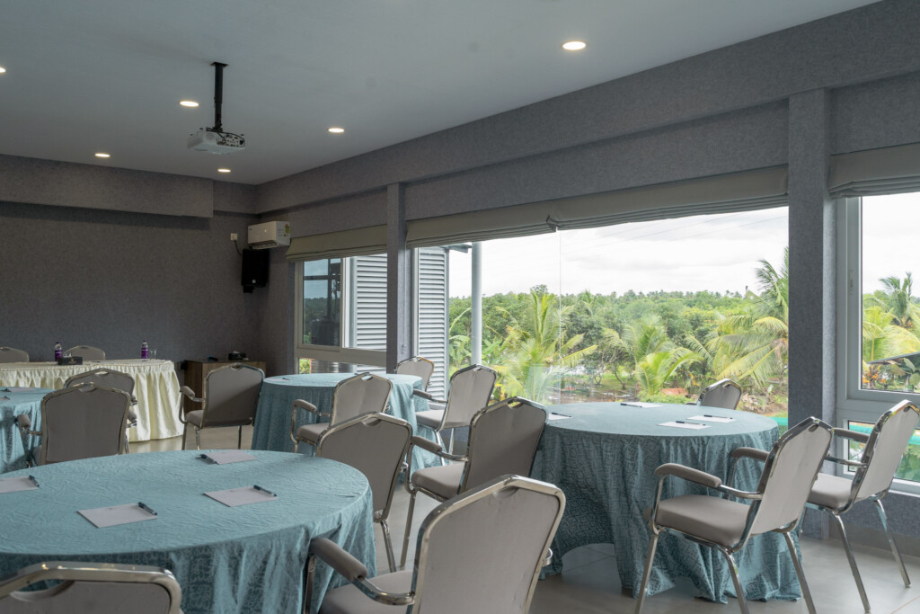 Banquet hall at Giby Farm set with round tables and teal linen