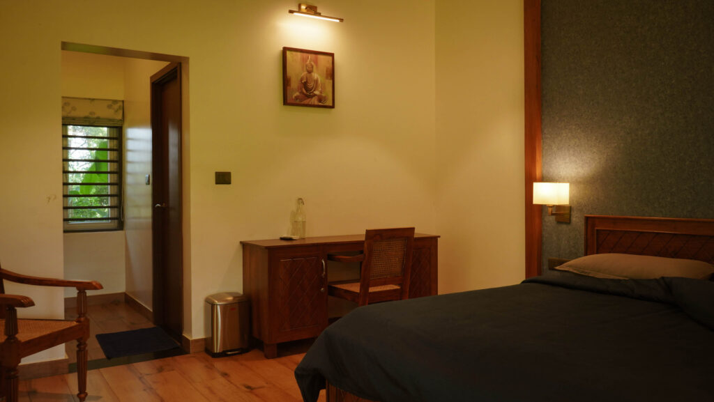 Bedroom in Kanikonna villa at Giby Farm with wooden furniture and warm lighting