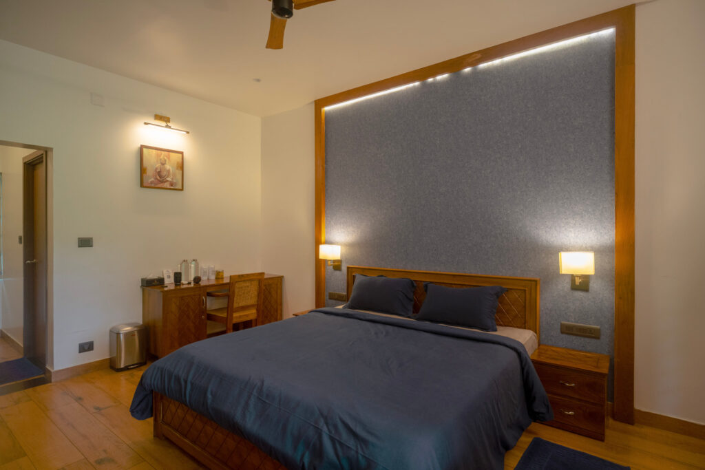 Bedroom in Mandaram villa at Giby Farm with a full length mirror and wall lights