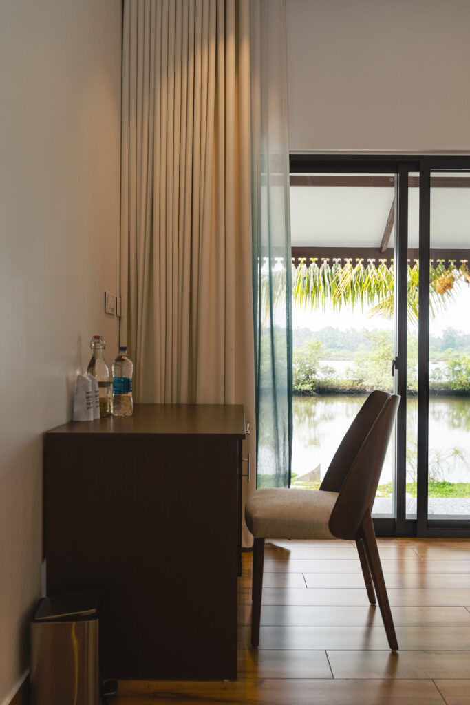 Bedroom at Giby Farm with a work desk beside glass doors to the garden
