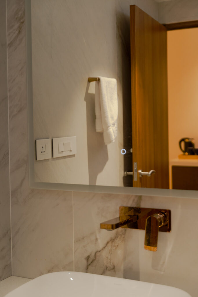 Marble bathroom with a wall mounted tap and bathtub in a Giby Farm villa