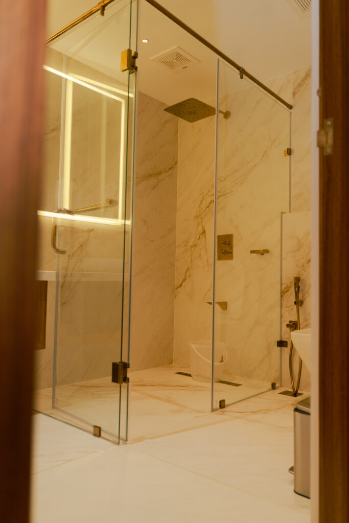 Glass walk in shower in a marble finished bathroom at Giby Farm