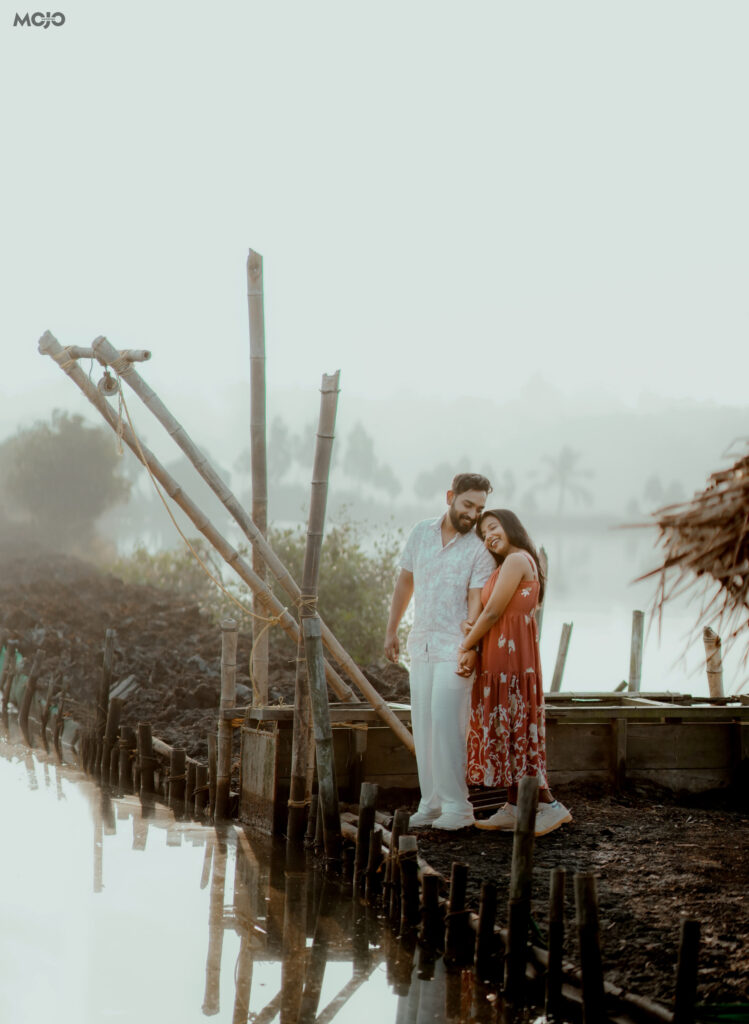 Couple photographed beside the Chinese fishing nets on the water at Giby Farm