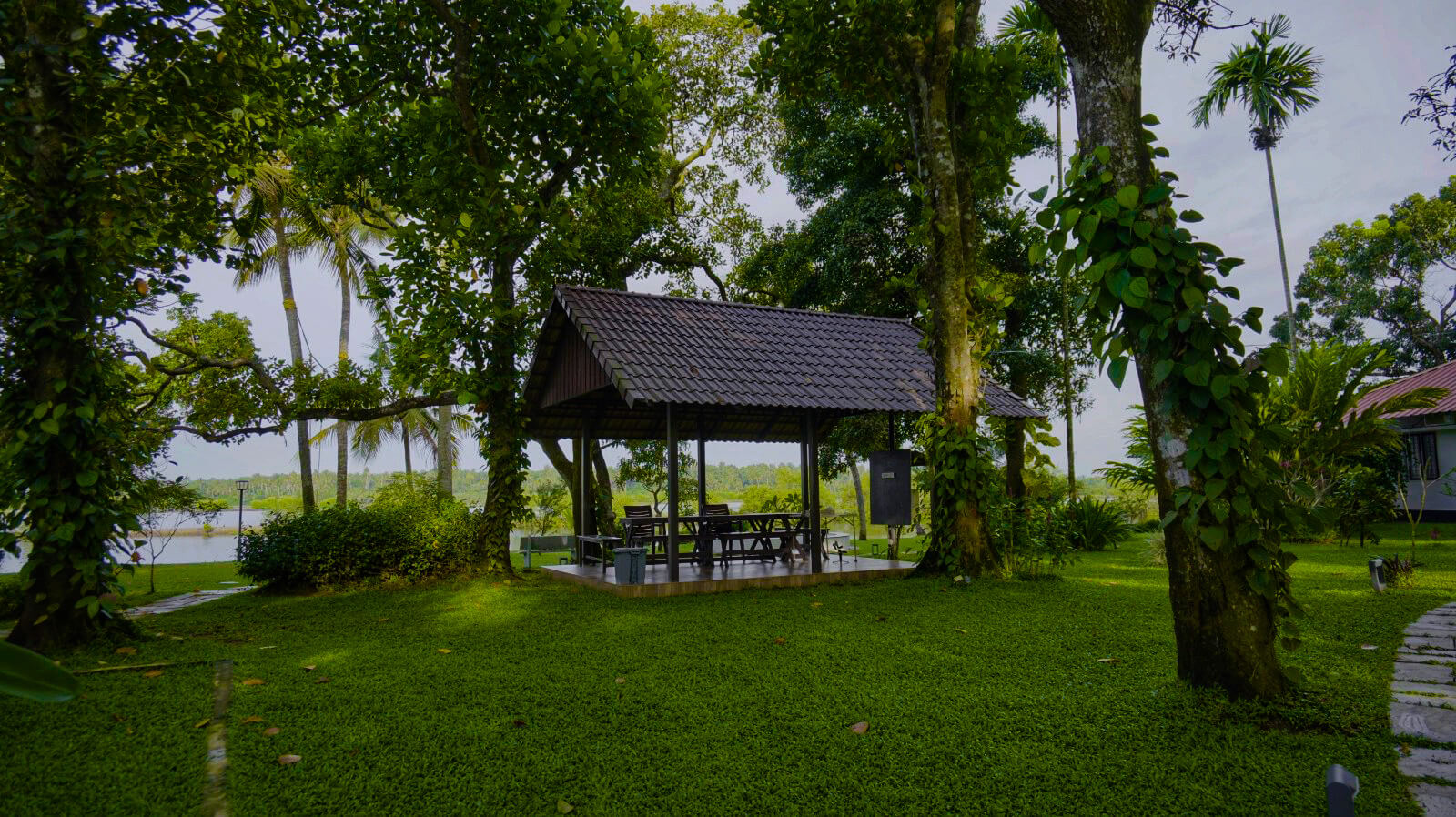 Lakeside gazebo on the lawn at Giby Farm, surrounded by palms and greenery