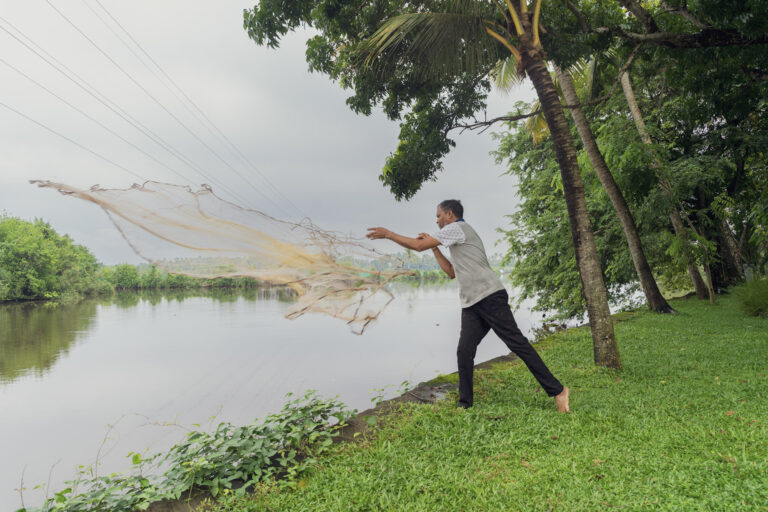 Guest casting a traditional fishing net into the backwater at Giby Farm