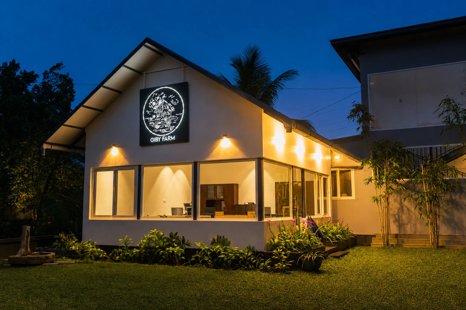 The Giby Farm reception building lit up at dusk, with its logo above the entrance